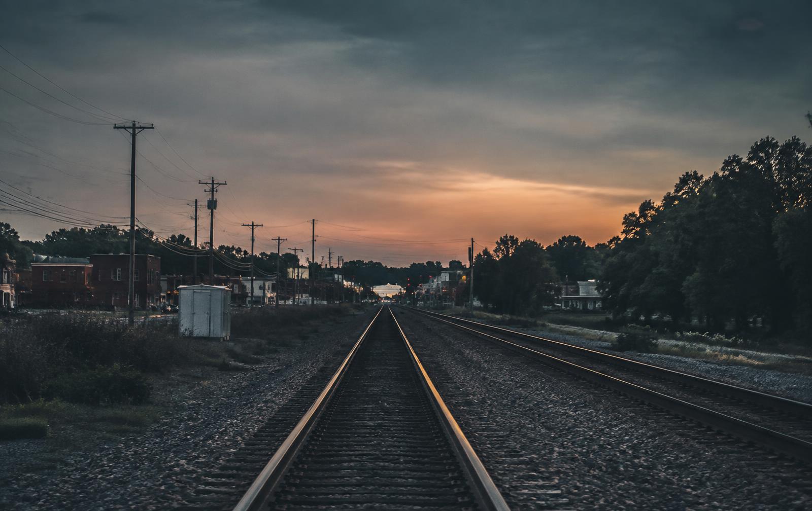 Railroad tracks running past a small town at dusk